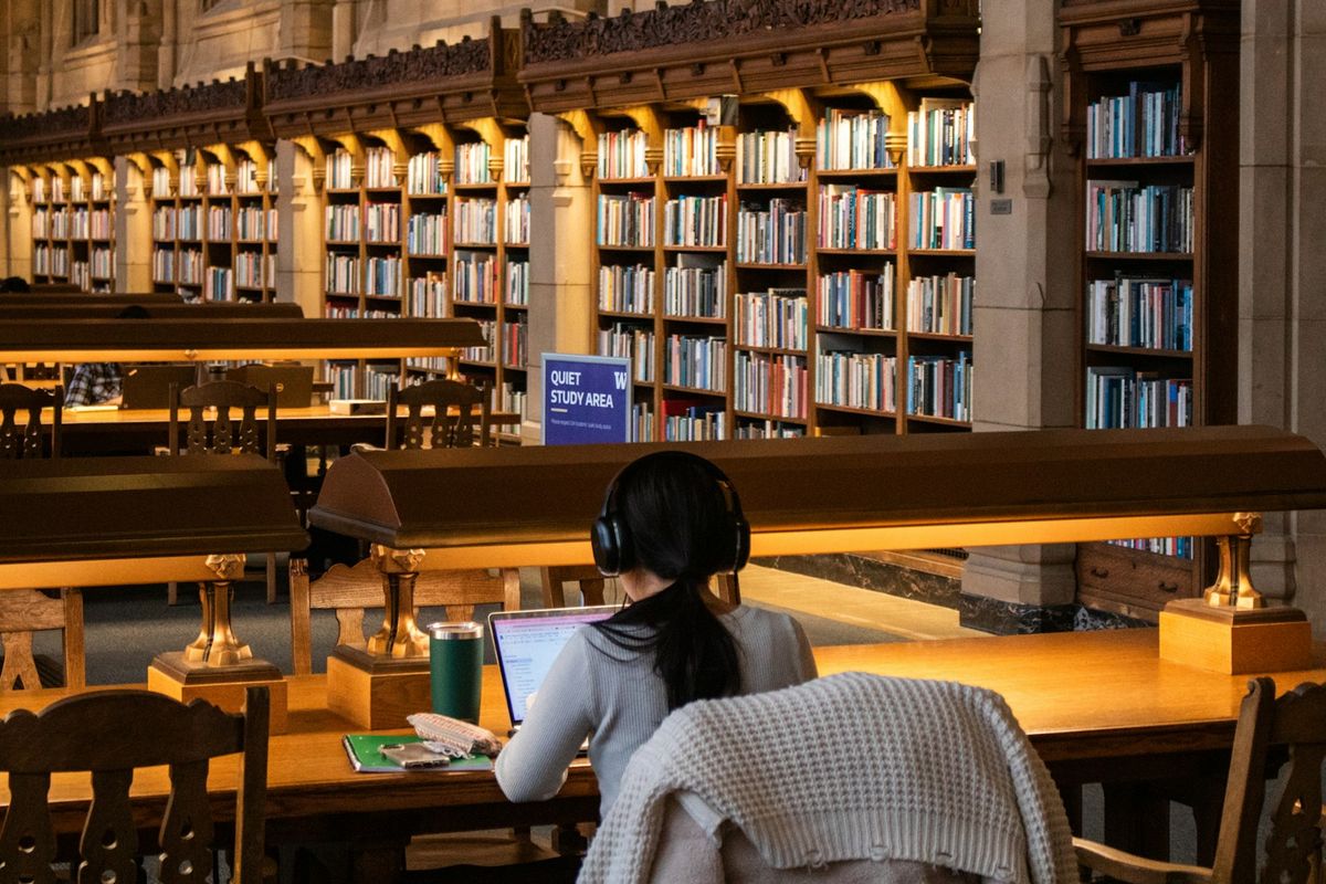 Student fordypet i bøker på biblioteket