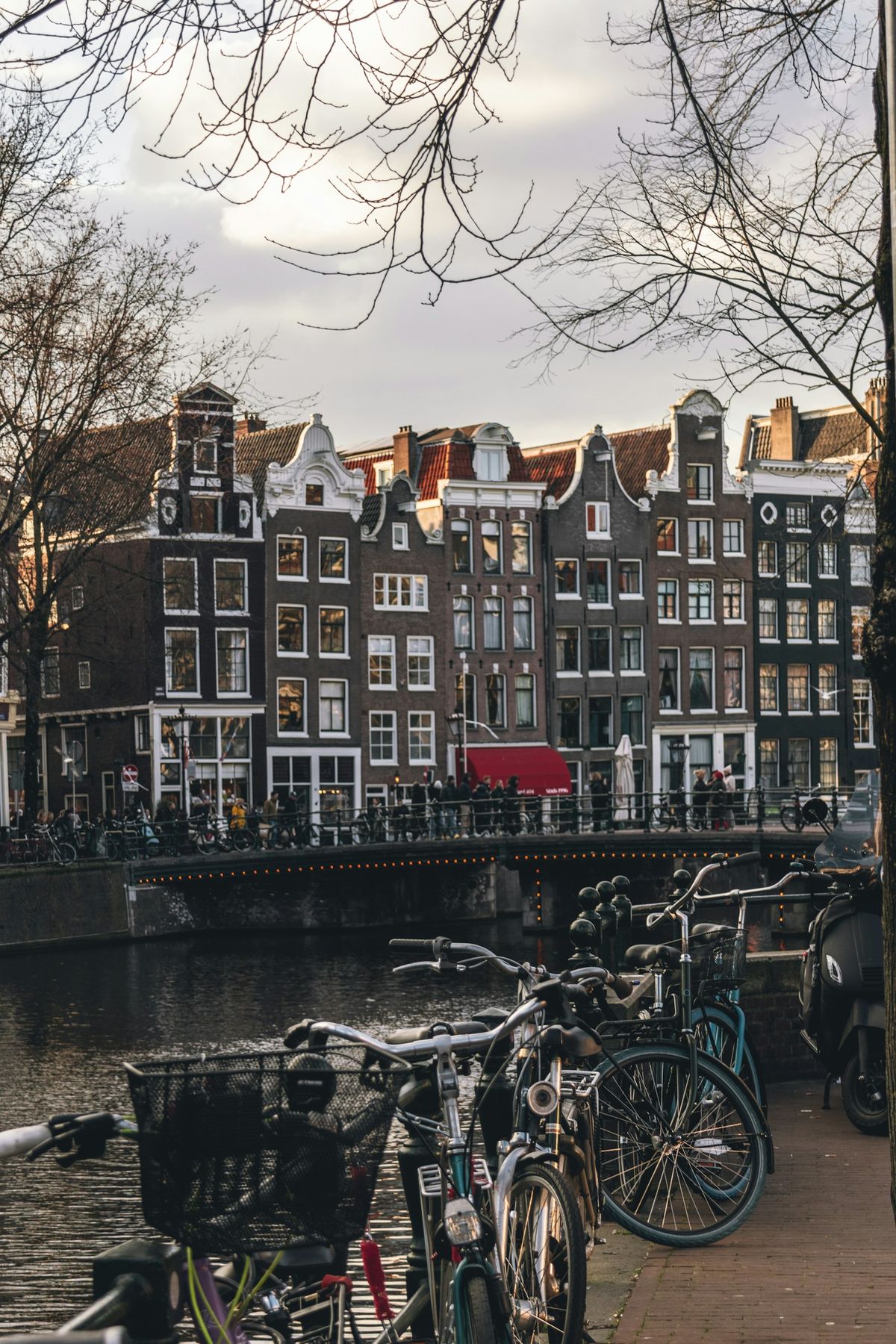 Kanal med sykler og historiske hus i Amsterdam